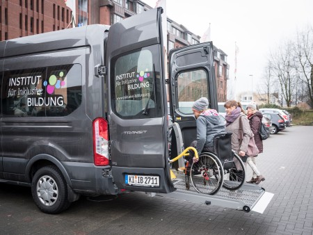 Rollstuhlfahrer wird mittels Heberampe in einen Transporter gehoben