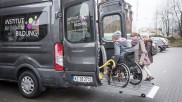 Rollstuhlfahrer wird mittels Heberampe in einen Transporter gehoben