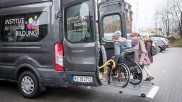 Rollstuhlfahrer wird mittels Heberampe in einen Transporter gehoben