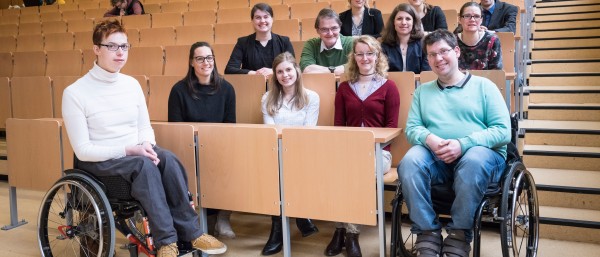 Vorlesungsraum mit Studenten und den zwei Kursleitern im Rollstuhl