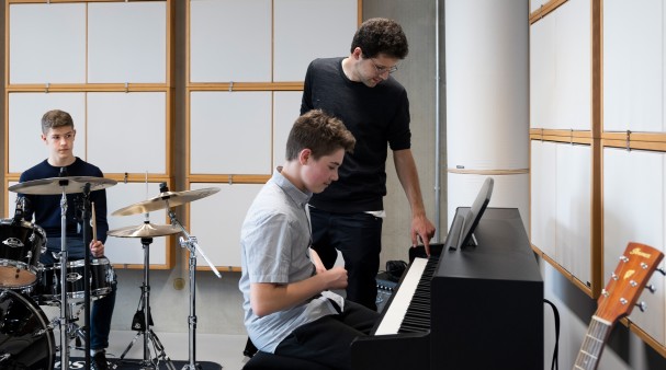 Pupils Maxim Parkhomenko (right) and Victor Grueter (left) receive music lessons from David Saposhnikov (centre) at the Tumo Center in Berlin.
