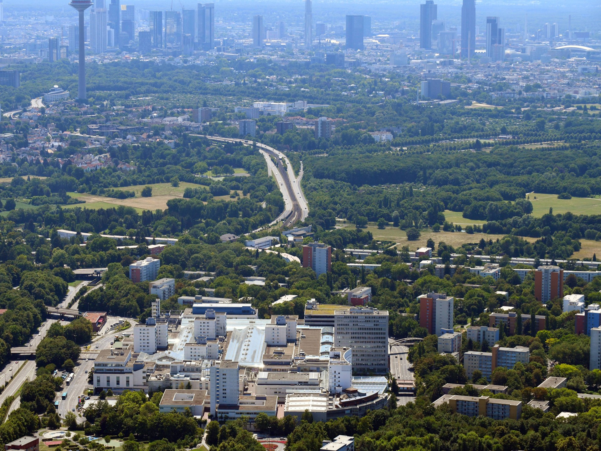 Ein Einkaufszentrum mit grüner Umgebung und ein Blick auf die Skyline der Stadt Frankfurt