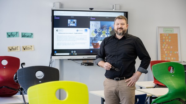 A teacher is standing in an empty class room