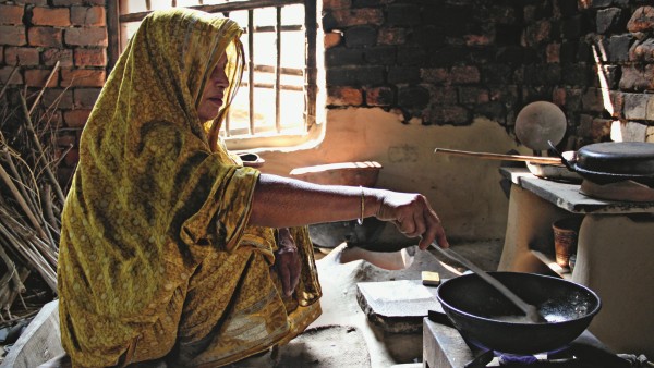 Woman cooking on biogas stove