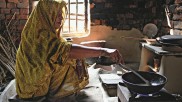 Woman cooking on biogas stove