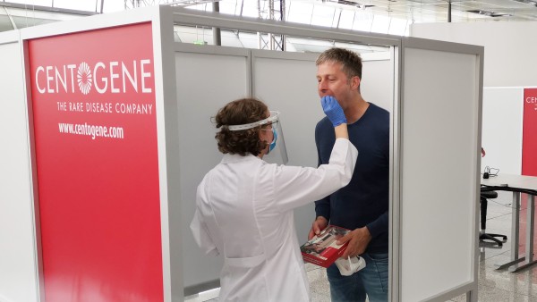 A Centogene employee takes a throat swab on a passenger