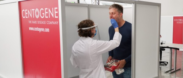 A Centogene employee takes a throat swab on a passenger