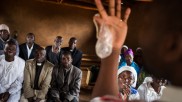 A condom is shown during a hiv prevention seminar for priests and other listeners