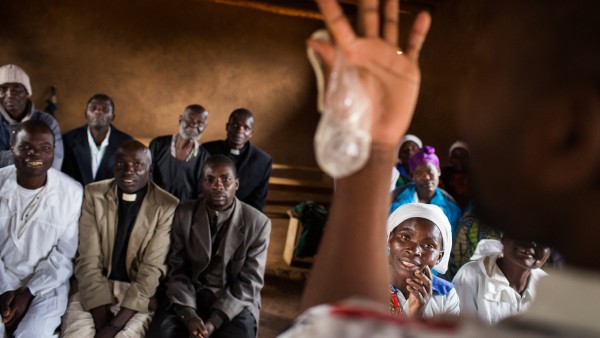 A condom is shown during a hiv prevention seminar for priests and other listeners