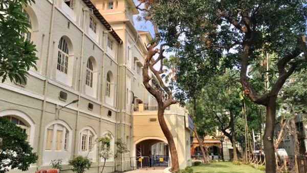 Renovated hospital with trees and green area in front of it