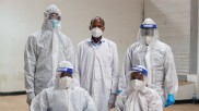 Men in protective suits and masks in a mobile laboratory in Kenya