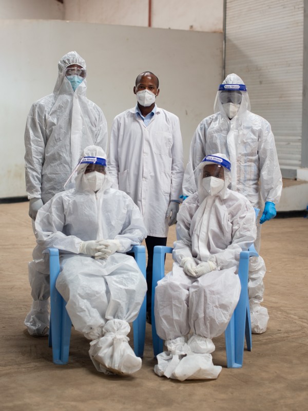 Men in protective suits and masks in a mobile laboratory in Kenya