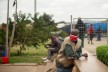Ein Mann aus Kenia wartet mit einer roten Schutzmaske auf einem öffentlichen Platz