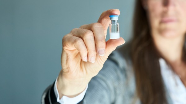 Eine Frau hält eine Ampule mit Hepcludex, Pulver zur Herstellung von Injektionszubereitung in Ihrer Hand