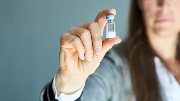 Eine Frau hält eine Ampule mit Hepcludex, Pulver zur Herstellung von Injektionszubereitung in Ihrer Hand