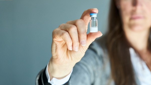 Eine Frau hält eine Ampule mit Hepcludex, Pulver zur Herstellung von Injektionszubereitung in Ihrer Hand