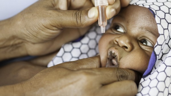 Baby in Afrika während der Verabreichung der Polioschluckimpfung