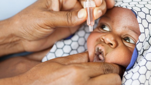 Baby in Afrika während der Verabreichung der Polioschluckimpfung