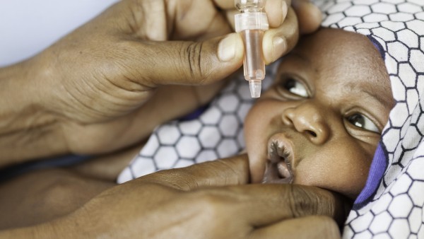 Baby in Afrika während der Verabreichung der Polioschluckimpfung