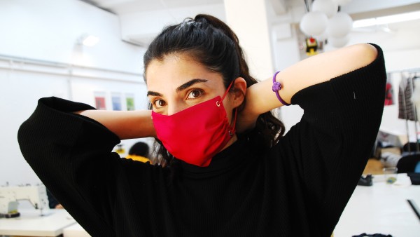 Demonstration of a red protective mask manufactured by Stitch by Stitch