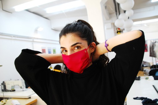 Demonstration of a red protective mask manufactured by Stitch by Stitch