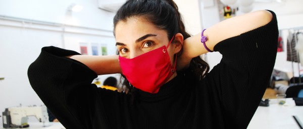 Demonstration of a red protective mask manufactured by Stitch by Stitch