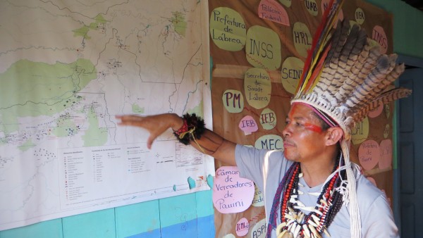 Member of a tribe shows protected area on a map.