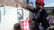 Eine Frau füllt Wasser in Äthiopien ab