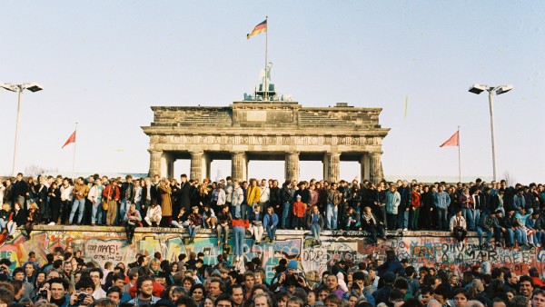 Menschenmenge auf und vor der Berliner Mauer am Brandenburger Tor