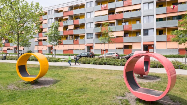Seating in the form of an erected circle on a lawn in front of panel building.