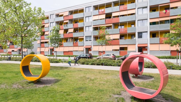 Seating in the form of an erected circle on a lawn in front of panel building.