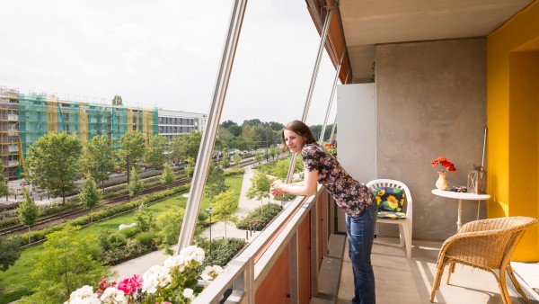 Eine Bewohnerin der Gartenstadt Potsdam-Drewitz steht auf ihrem Balkon