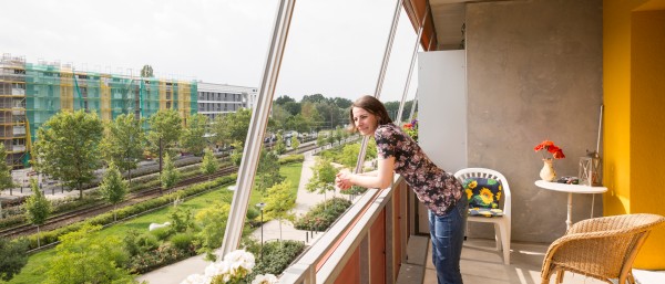 Eine Bewohnerin der Gartenstadt Potsdam-Drewitz steht auf ihrem Balkon