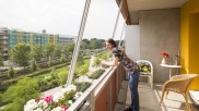 Eine Bewohnerin der Gartenstadt Potsdam-Drewitz steht auf ihrem Balkon