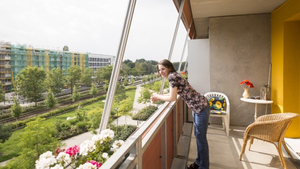 Eine Bewohnerin der Gartenstadt Potsdam-Drewitz steht auf ihrem Balkon