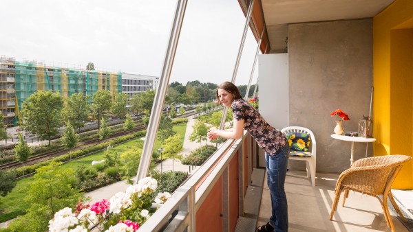 Eine Bewohnerin der Gartenstadt Potsdam-Drewitz steht auf ihrem Balkon