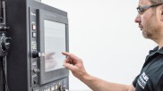 Ein Mitarbeiter bedient die Maschine per Touchscreen