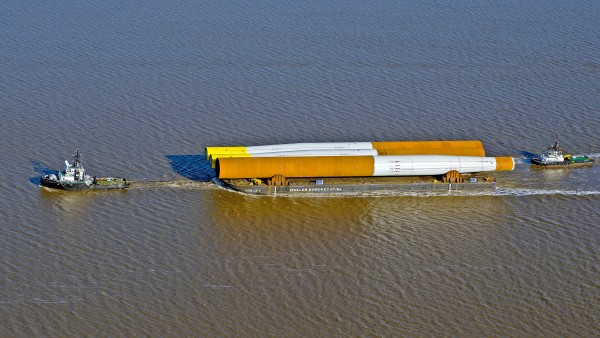 Ein Schlepper zieht eine Barkasse mit Aufbauten für Ofshore Windanlagen