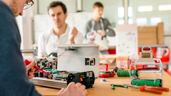 Technicians working on the electrics of the battery