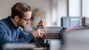 An employee is working with a battery