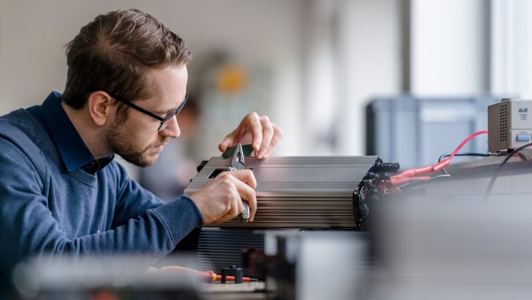 An employee is working with a battery