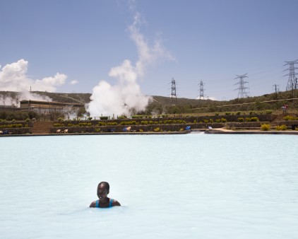 A woman takes a swim in a cooling basin at Olkaria geothermal power plant