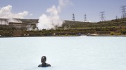 A woman takes a swim in a cooling basin at Olkaria geothermal power plant