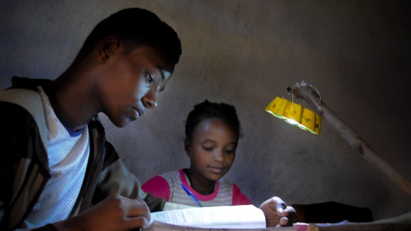 School children doing their homework, illuminated by a Little Sun solar lamp