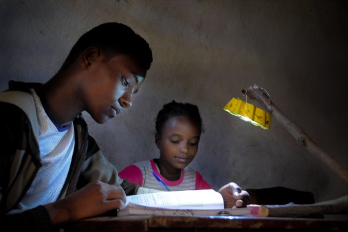 School children doing their homework, illuminated by a Little Sun solar lamp