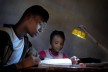 School children doing their homework, illuminated by a Little Sun solar lamp