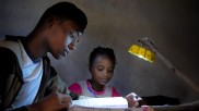 School children doing their homework, illuminated by a Little Sun solar lamp