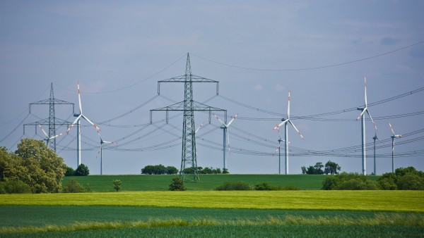 Landschaft mit Strommasten und Windkraftanlagen