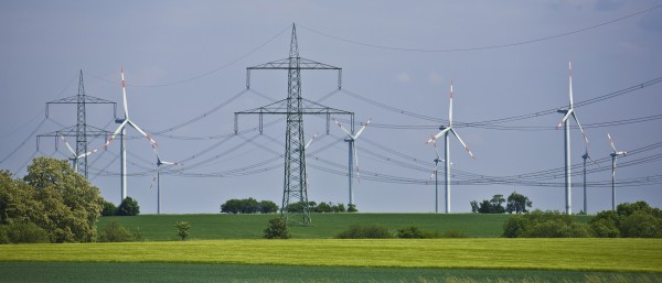 Landschaft mit Strommasten und Windkraftanlagen