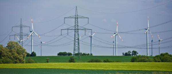 Landschaft mit Strommasten und Windkraftanlagen